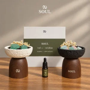 within fragrance oil bottle with gift box and white and black fluorite crystal diffuser vessels on wood